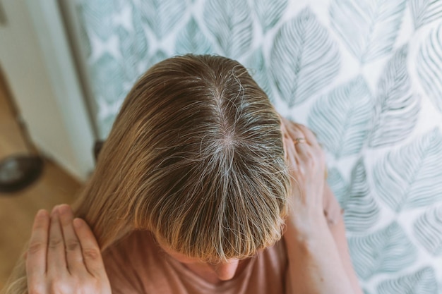 Blond woman with gray hair requiring coloring