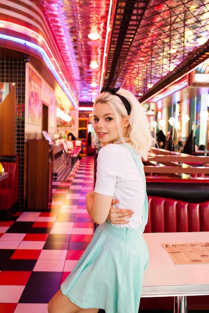 Photo blonde adorable female in american classic retro cafe standing and flirting