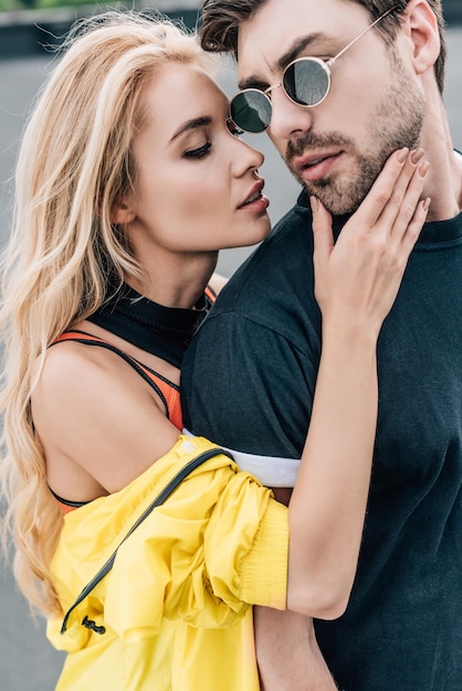 Blonde and attractive woman hugging with handsome man in glasses