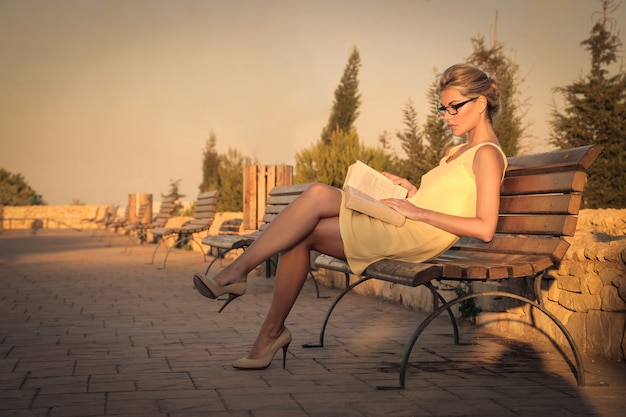 Blonde beautiful woman reading on the street