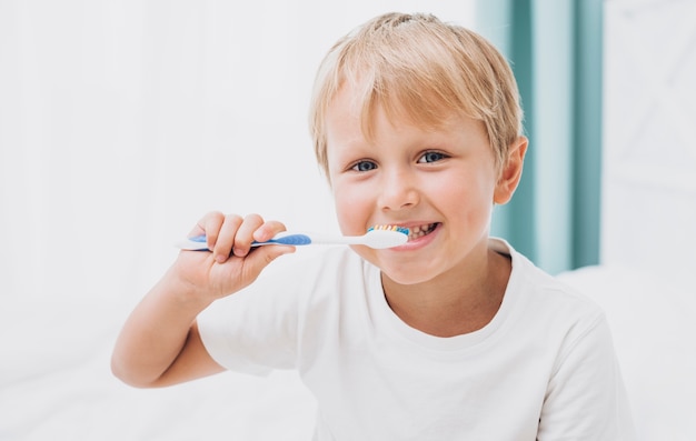 Blonde boy brushing his teeth