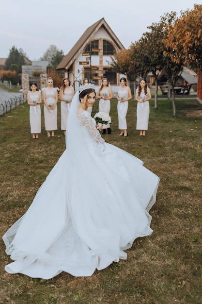 A blonde bride in a long wedding dress and her friends in beige dresses