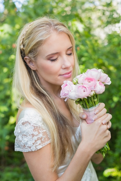 Blonde bride smelling her bouquet