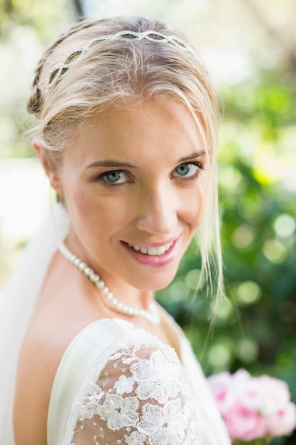 Blonde bride in a veil smiling to camera