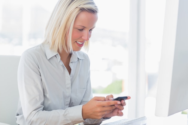 Blonde businesswoman texting