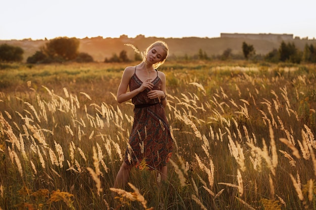 blonde in a field at sunset