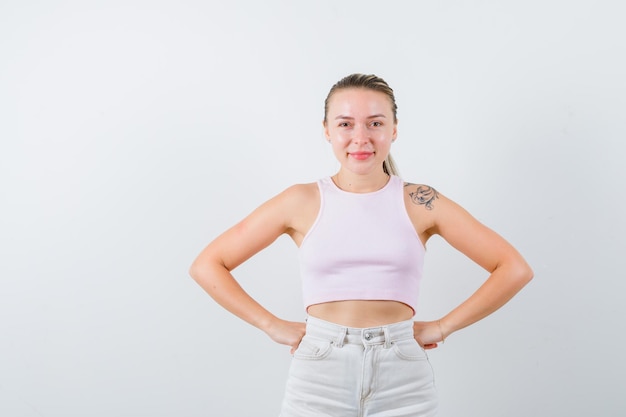 Blonde girl is posing for camera on white background