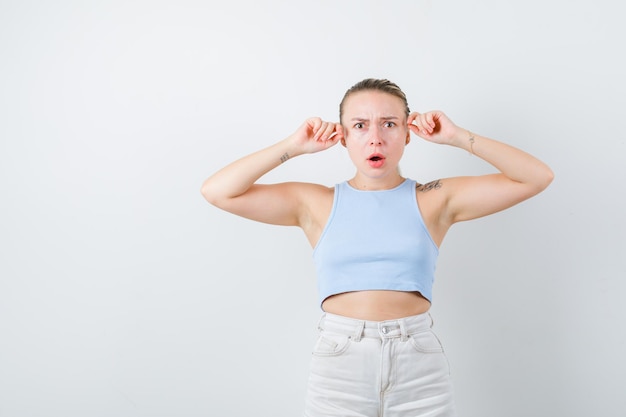 Blonde girl is showing baffled emotion on white background