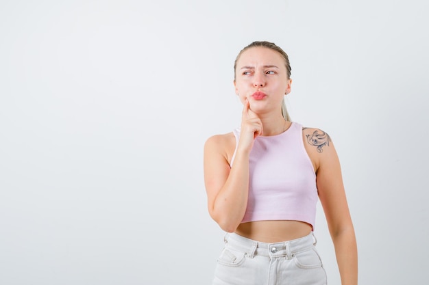 Blonde girl is showing her toothache on white background