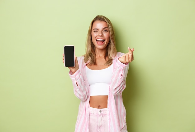 Blonde girl in a pink outfit posing