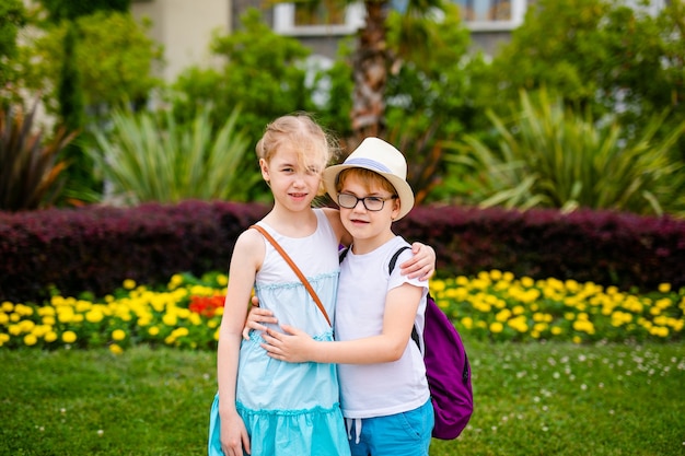 Blonde girl in white and blue dress and ginger boy in the hat and big glasses