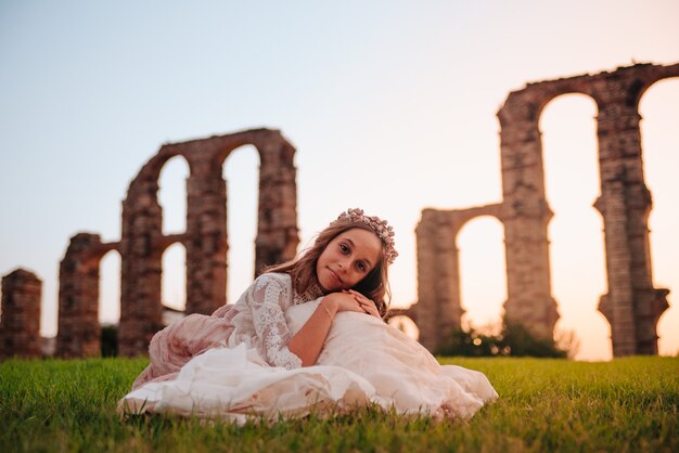 Blonde girl with curly hair dressed in communion dress in Merida