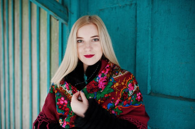 Blonde girl with hand embroidered scarf posed at winter day.