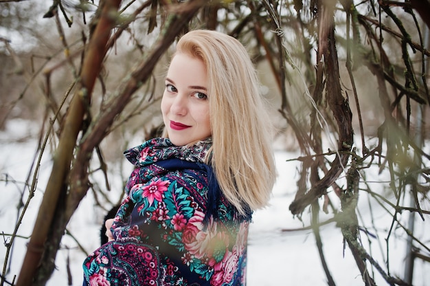 Blonde girl with hand embroidered scarf posed at winter day.