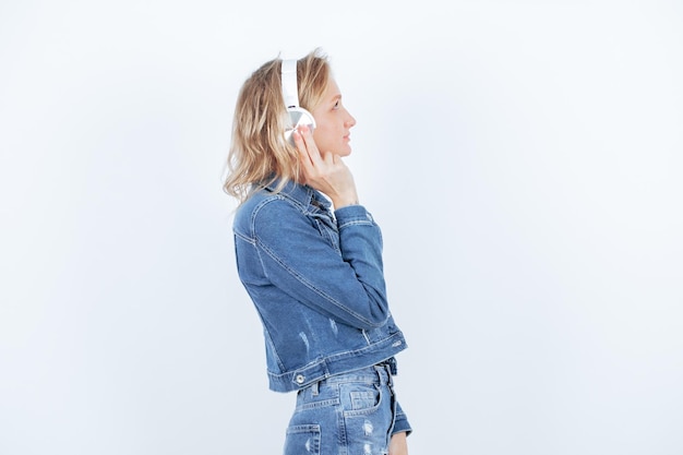 Blonde girl with headphone is turning to right on white background