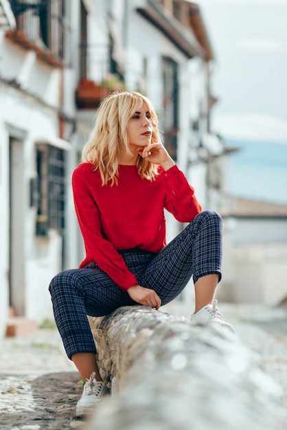 Blonde girl with red shirt enjoying life outdoors.