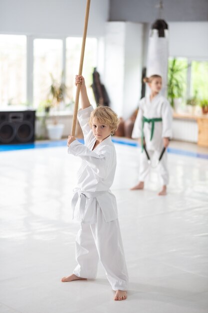 Blonde-haired teen boy studying martial arts practicing