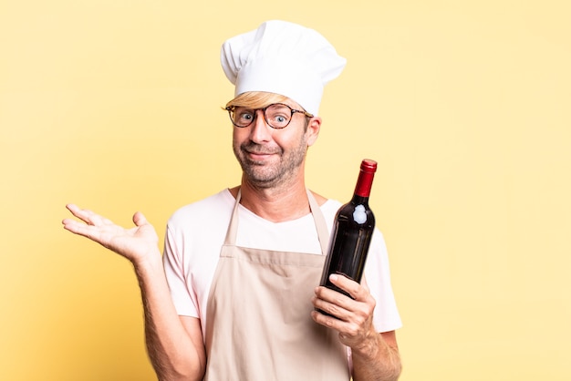 blonde handsome chef  adult man holding a bottle of wine