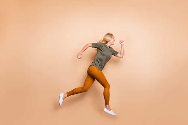 Blonde lady posing against the beige wall