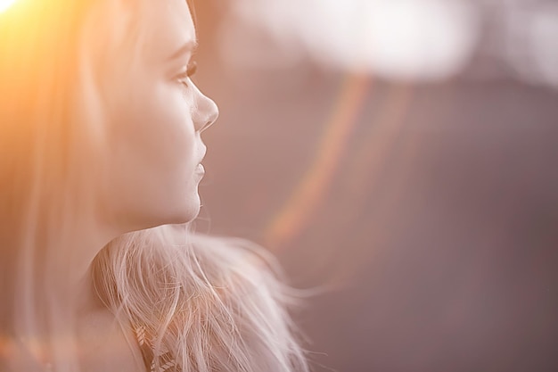 blonde long hair nature summer / happy adult girl with developing in the wind long blonde hair in the summer field