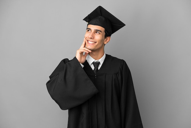 Blonde man sitting on the floor showing and lifting a finger in sign of the best