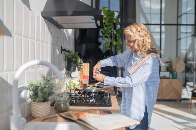 Blonde mature pretty woman cooking in the kitchen