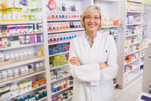 Blonde pharmacist with arms crossed smiling at camera