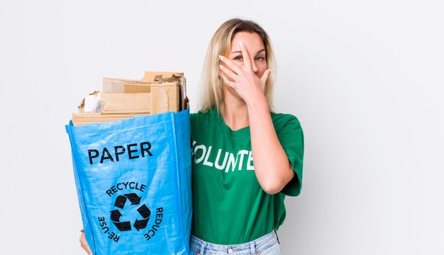 Blonde pretty woman looking shocked scared or terrified covering face with hand recycle concept