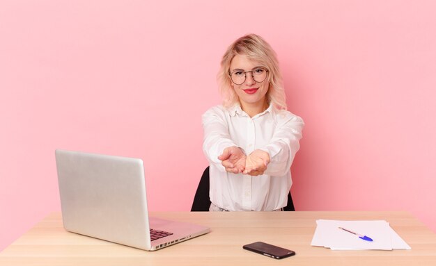 blonde pretty woman young pretty woman smiling happily with friendly and  offering and showing a concept. workspace desk concept