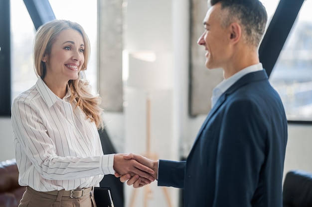 Blonde specialist welcoming the male customer in her office