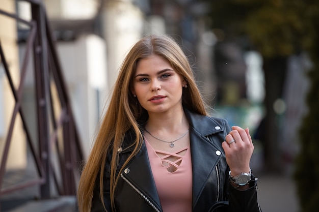 blonde student walking down city street