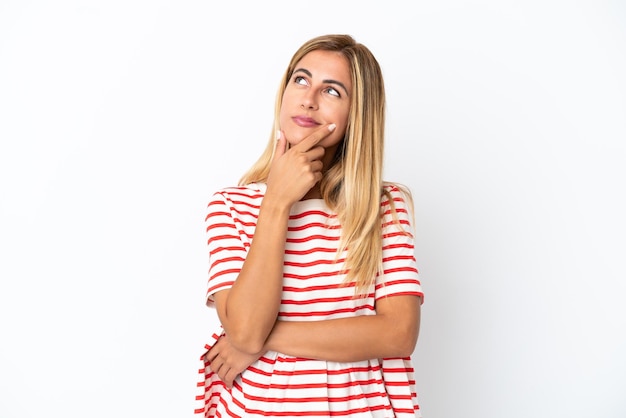 Blonde Uruguayan girl isolated on white background having doubts