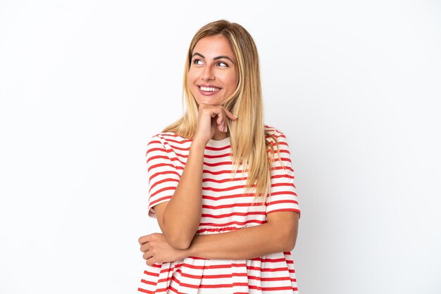 Blonde Uruguayan girl isolated on white background and looking up