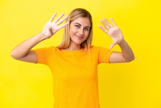 Photo blonde uruguayan girl isolated on yellow background counting nine with fingers