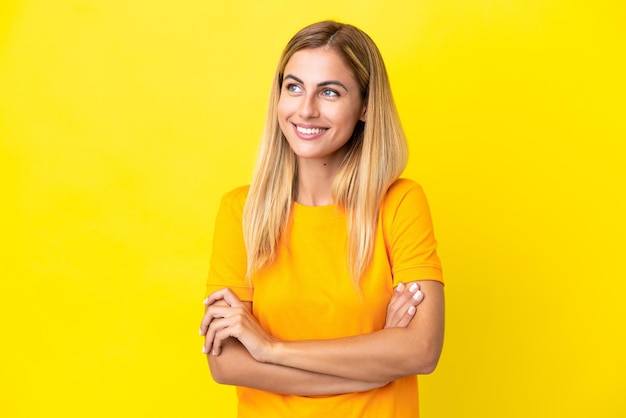 Blonde Uruguayan girl isolated on yellow background happy and smiling