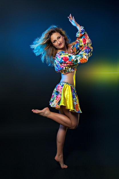 Blonde woman dancing in front of black background