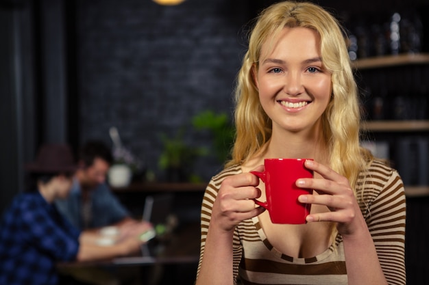 Blonde woman drinking a cup of coffee