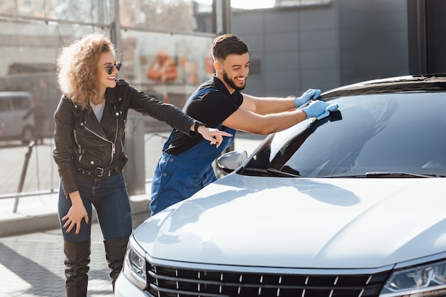 Blonde woman help to washer cleaning her car.