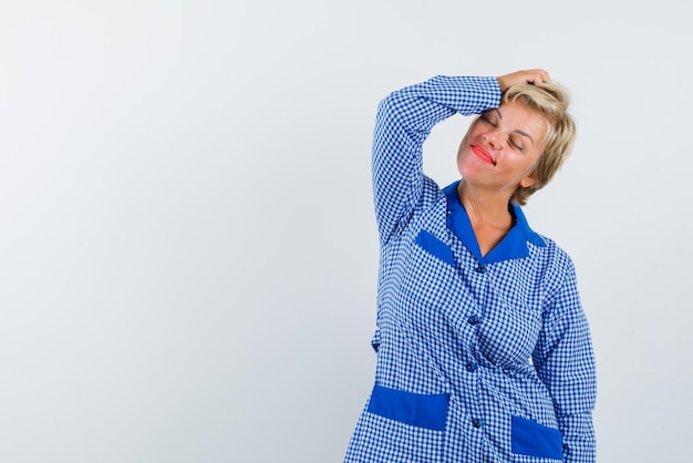 The blonde woman is dreaming by putting her hand on head on white background