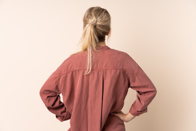 Photo blonde woman over isolated background in back position