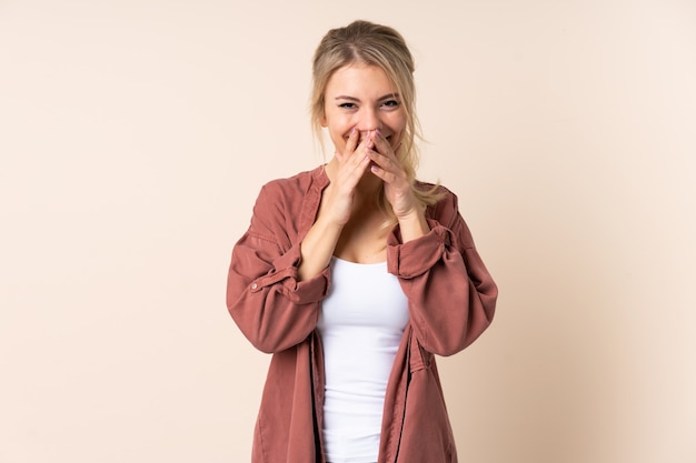 Blonde woman over isolated happy and smiling covering mouth with hands