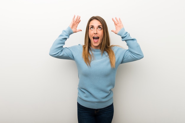 Blonde woman on isolated white background with surprise and shocked facial expression