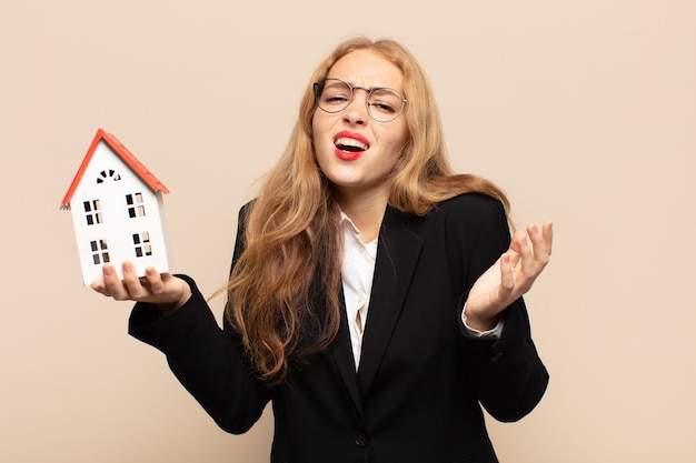 Blonde woman looking desperate and frustrated, stressed, unhappy and annoyed, shouting and screaming