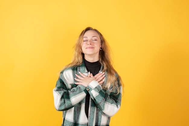 Photo blonde woman meditating on yellow background