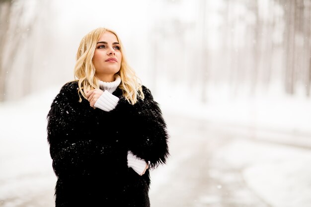 Blonde woman outside in snow winter coat