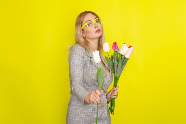 Blonde woman in plaid dress holding tulips bouquet