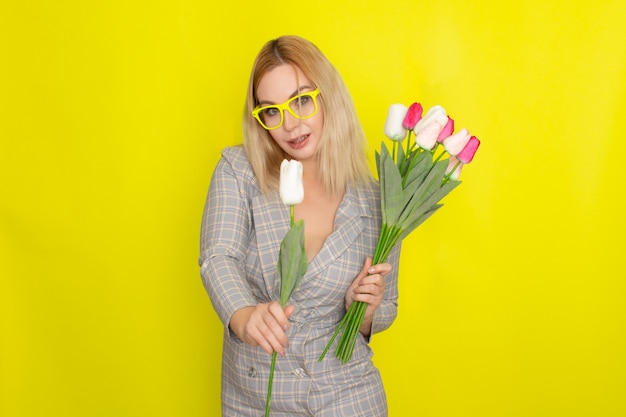 Blonde woman in plaid dress holding tulips bouquet