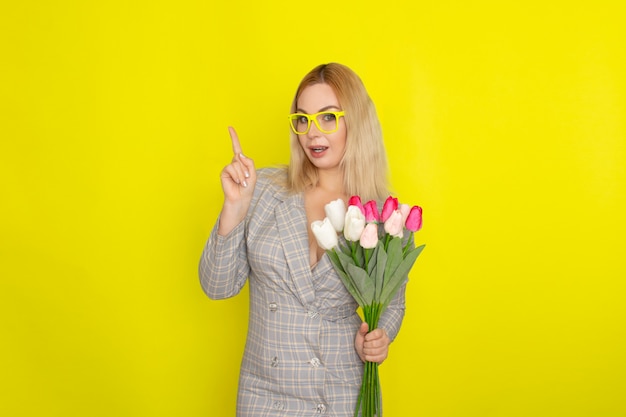 Blonde woman in plaid dress holding tulips bouquet