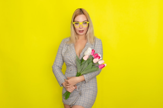 Blonde woman in plaid dress holding tulips bouquet