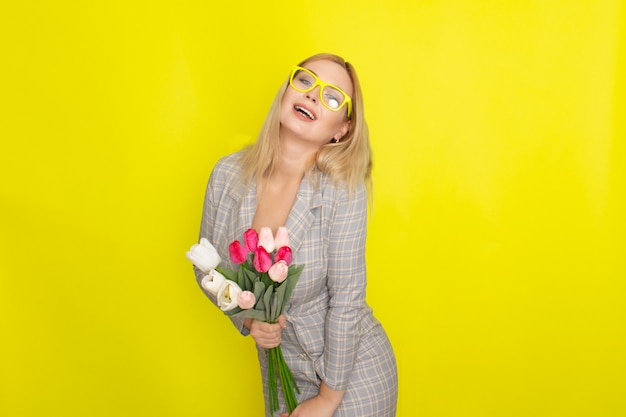 Blonde woman in plaid dress holding tulips bouquet